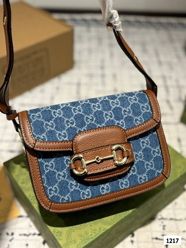The Gucci 1955 horseneck buckle handbag, packaged in a gift box, made a stunning debut in the early spring collection. This handbag continues the lines and styling of classic items from over sixty years ago, cleverly blending classic details with mod
