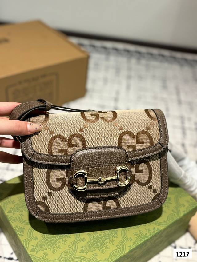 The Gucci 1955 horseneck buckle handbag, packaged in a gift box, made a stunning debut in the early spring collection. This handbag continues the lines and styling of classic items from over sixty years ago, cleverly blending classic details with mod