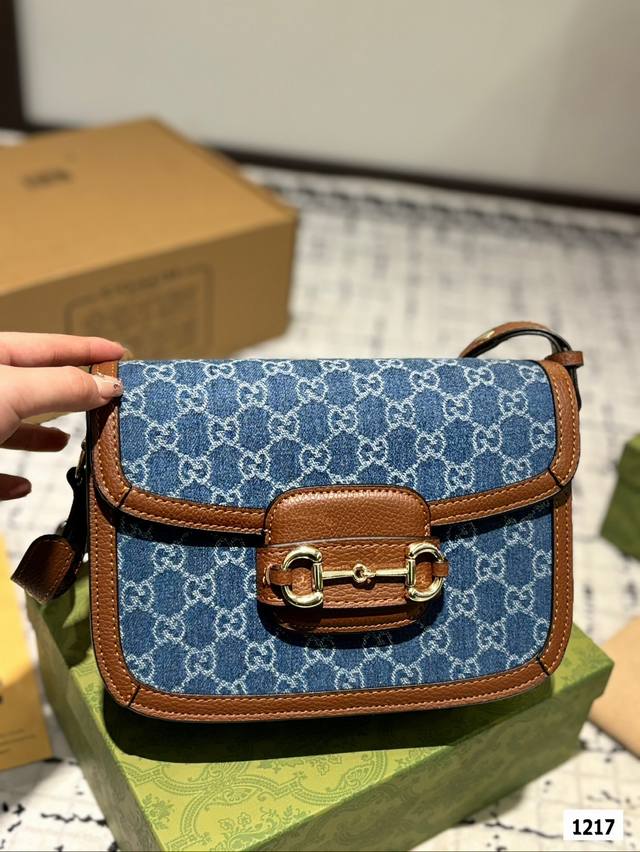 The Gucci 1955 horseneck buckle handbag, packaged in a gift box, made a stunning debut in the early spring collection. This handbag continues the lines and styling of classic items from over sixty years ago, cleverly blending classic details with mod