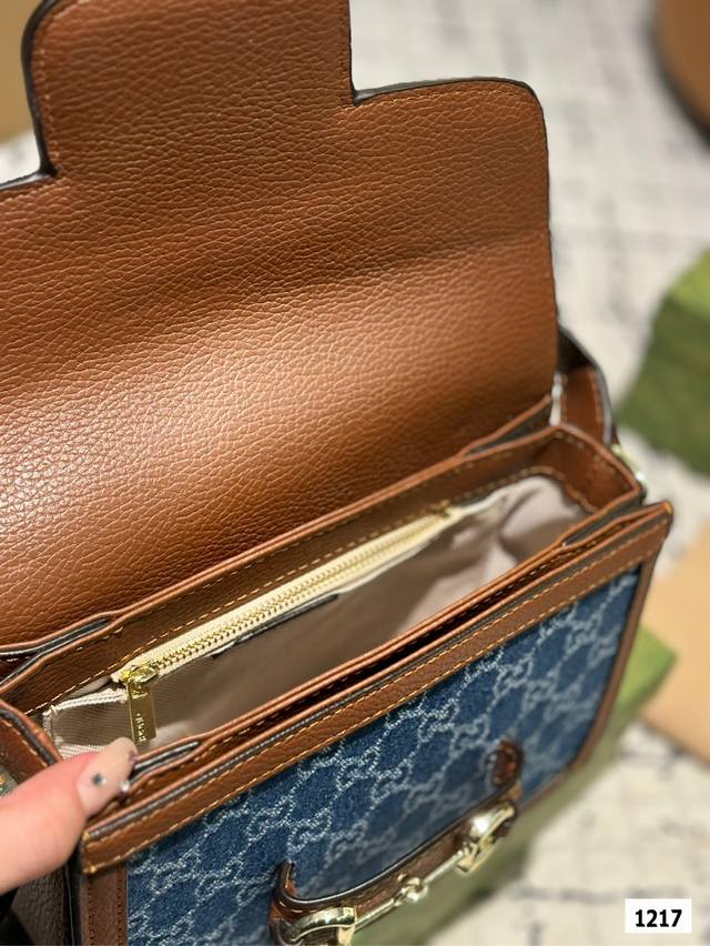 The Gucci 1955 horseneck buckle handbag, packaged in a gift box, made a stunning debut in the early spring collection. This handbag continues the lines and styling of classic items from over sixty years ago, cleverly blending classic details with mod