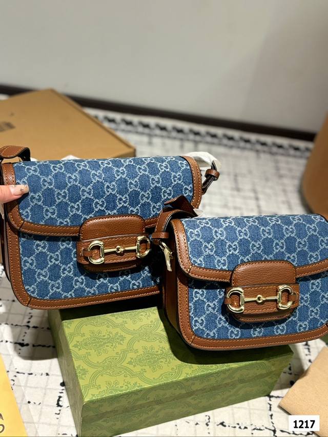 The Gucci 1955 horseneck buckle handbag, packaged in a gift box, made a stunning debut in the early spring collection. This handbag continues the lines and styling of classic items from over sixty years ago, cleverly blending classic details with mod