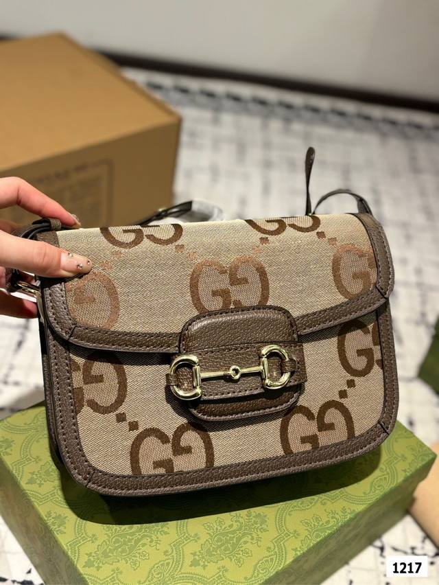 The Gucci 1955 horseneck buckle handbag, packaged in a gift box, made a stunning debut in the early spring collection. This handbag continues the lines and styling of classic items from over sixty years ago, cleverly blending classic details with mod