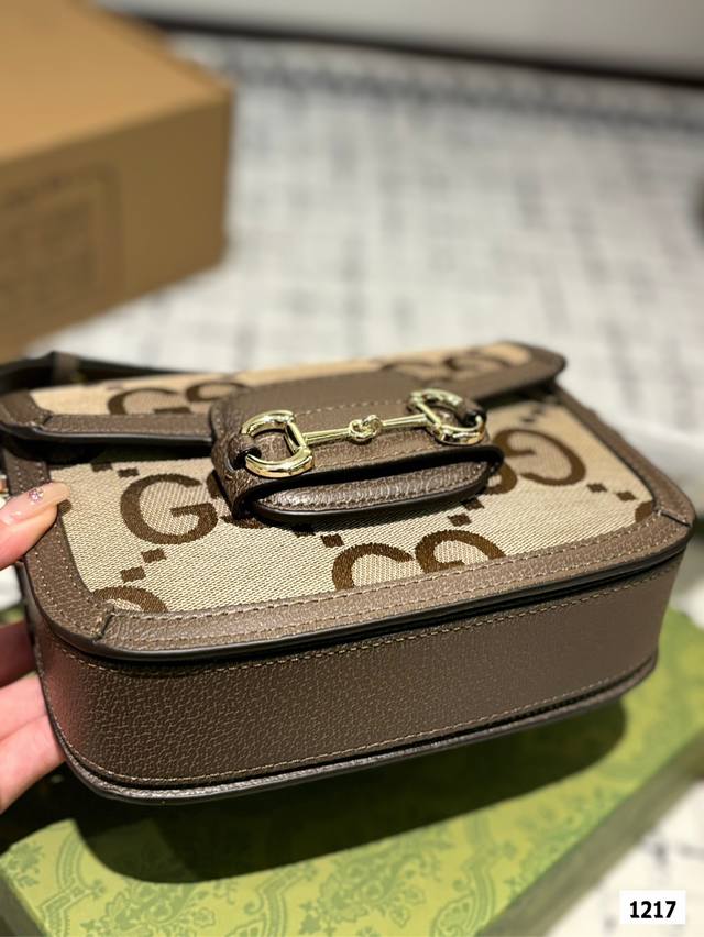 The Gucci 1955 horseneck buckle handbag, packaged in a gift box, made a stunning debut in the early spring collection. This handbag continues the lines and styling of classic items from over sixty years ago, cleverly blending classic details with mod